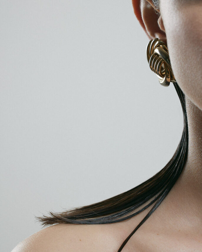 Photo studio d’un bijou minimaliste porté sur une épaule, avec un style épuré et élégant.