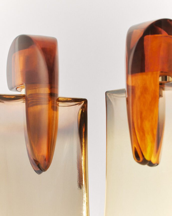 Photo produit en studio d’un parfum avec un effet miroir et une mise en scène élégante.