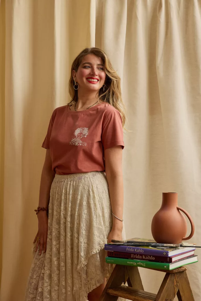 Femme souriante posant en studio avec un t-shirt terracotta et une jupe en dentelle – photographie mode à Lyon pour collection prêt-à-porter.