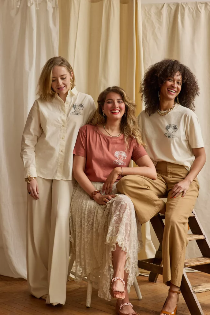 Trois femmes posent pour un shooting prêt-à-porter à Lyon, vêtues de pièces élégantes et naturelles aux tons doux, dans un décor studio en lumière naturelle.