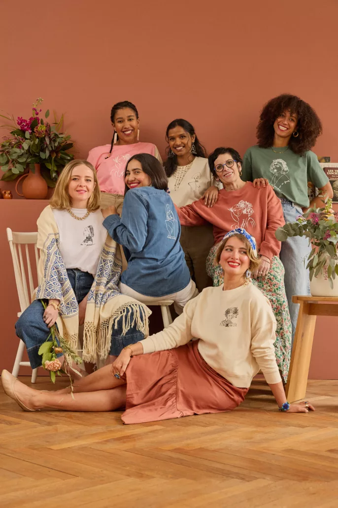 Groupe de femmes souriantes portant des vêtements de prêt-à-porter éthique, posant dans un décor chaleureux pour un shooting mode à Lyon.