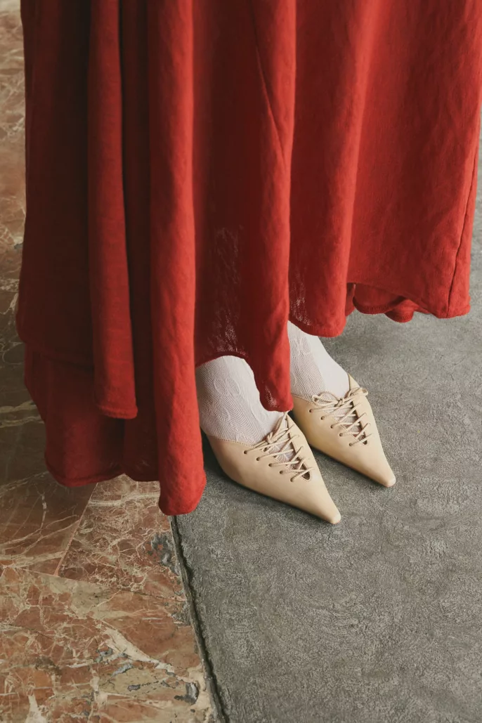 Gros plan sur des chaussures pointues beiges et robe rouge dans un décor minéral – Photographe mode éditorial à Lyon