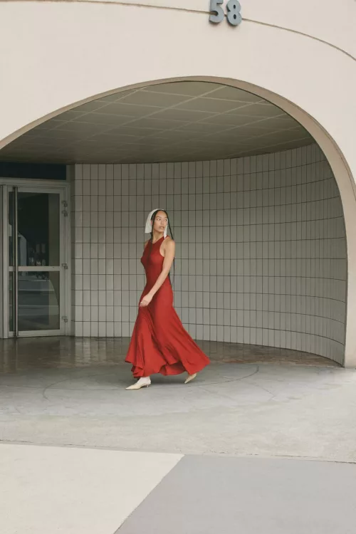 Femme en robe rouge marchant dans un décor graphique en extérieur – Photographe mode Lyon
