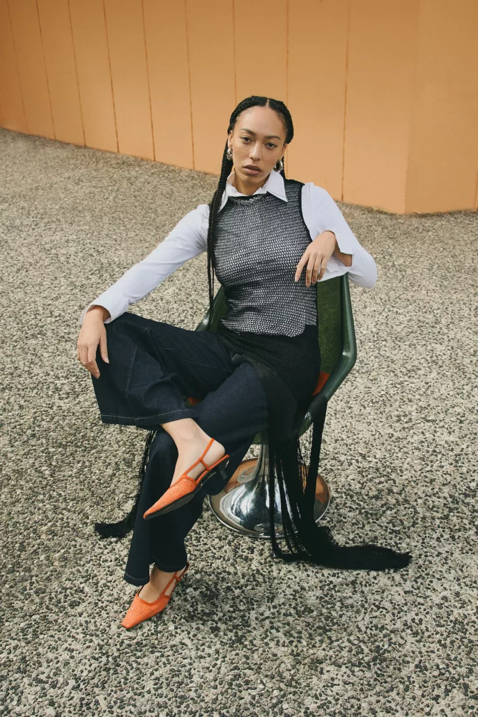 Modèle assise en look contrasté noir et blanc avec chaussures orange – Photographe mode éditorial à Lyon