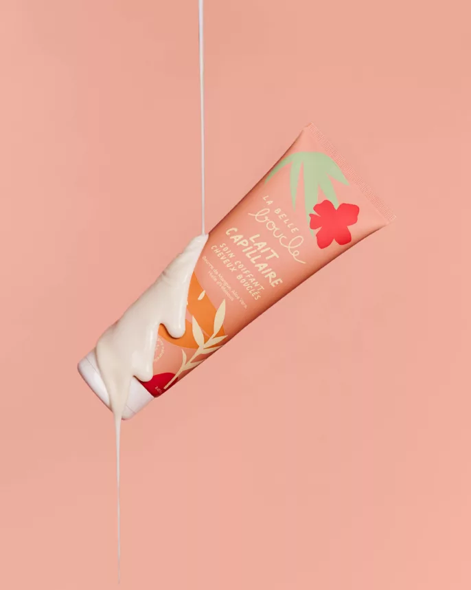 Tube de lait capillaire La Belle Boucle suspendu, texture qui s'écoule — shooting cosmétique Lyon, Stéphanie Lorang