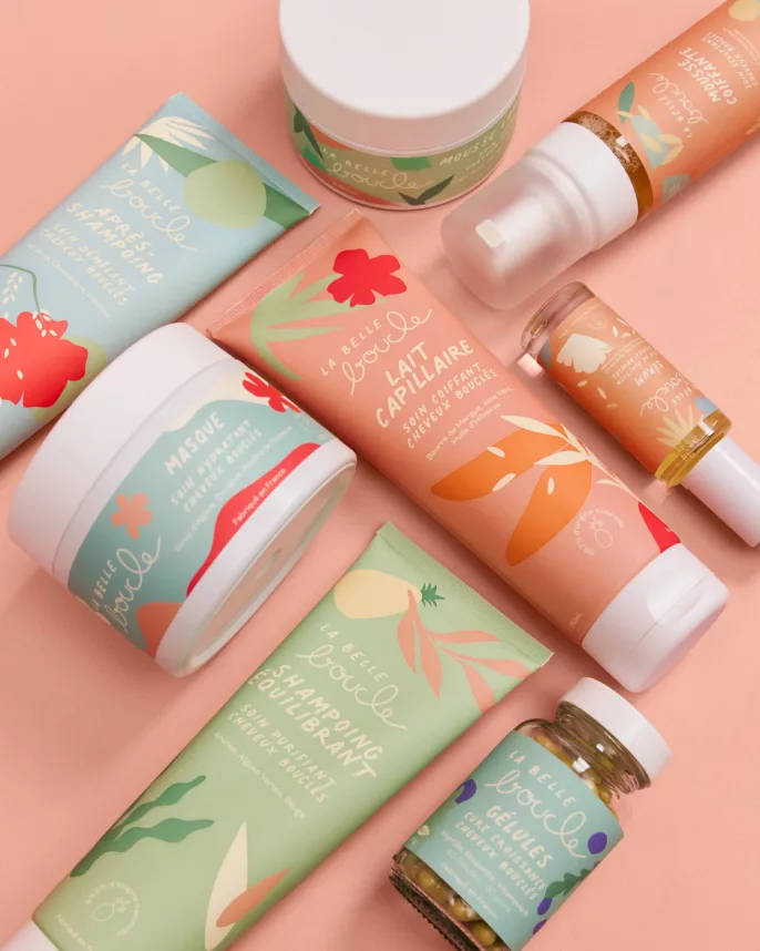 Flatlay de la gamme capillaire La Belle Boucle sur fond rose — shooting produit Lyon, Stéphanie Lorang