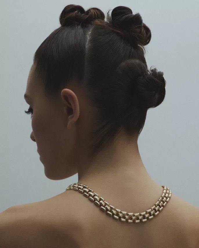 Dos de modèle aux chignons structurés portant un collier chaîne dorée — photographe bijoux Lyon, Stéphanie Lorang