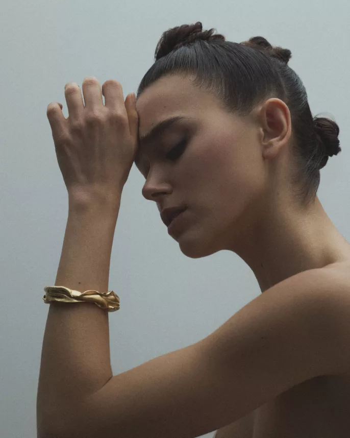 Modèle de profil yeux fermés portant un bracelet jonc doré froissé — portrait bijoux studio Lyon, Stéphanie Lorang