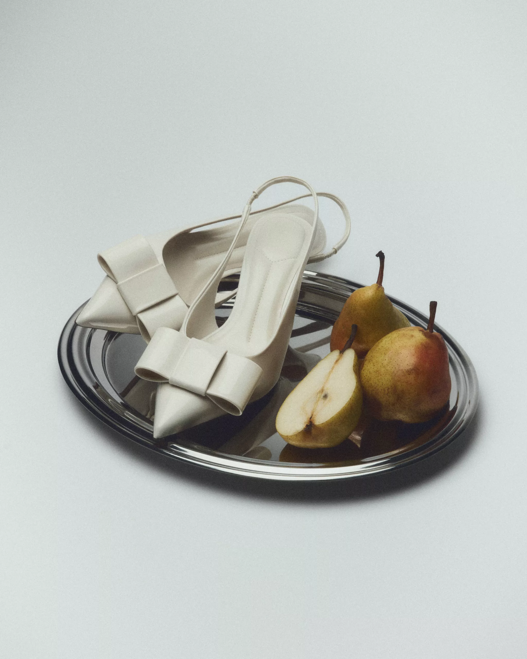 Escarpins crème à nœud et poires sur plateau argenté — photographie éditoriale mode studio Lyon, Stéphanie Lorang